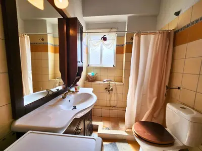 a bathroom with a sink and a toilet and a mirror at Roof Garden Loft in Athens