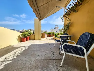 a patio with chairs and a table on a balcony at Roof Garden Loft in Athens