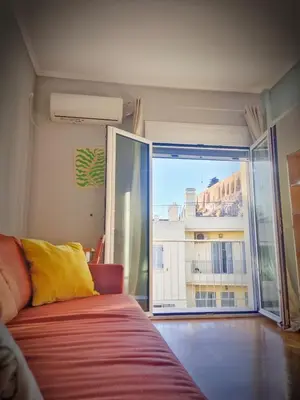 a room with a bed and a large window at Cosy Plaka flat with view of Acropolis Parthenon in Athens