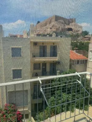 a view of a building from a balcony at Cosy Plaka flat with view of Acropolis Parthenon in Athens