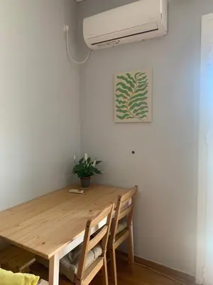 a dining room table with two chairs and a fan at Cosy Plaka flat with view of Acropolis Parthenon in Athens