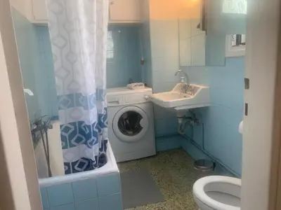 a bathroom with a washing machine and a sink at Cosy Plaka flat with view of Acropolis Parthenon in Athens