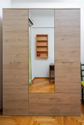 a large wooden cabinet with a mirror in a room at Comfy Apartment In Exarchia Vibrant Neighborhood in Athens