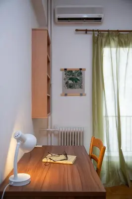 a table with a lamp and glasses on top of it at Comfy Apartment In Exarchia Vibrant Neighborhood in Athens