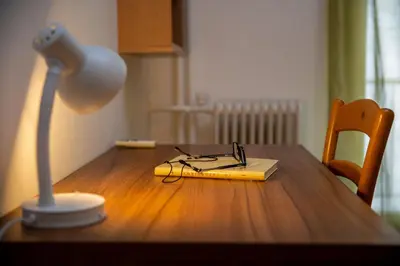 a book on a table with a lamp and glasses at Comfy Apartment In Exarchia Vibrant Neighborhood in Athens