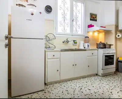 a kitchen with white cabinets and a white refrigerator at Comfy Apartment In Exarchia Vibrant Neighborhood in Athens