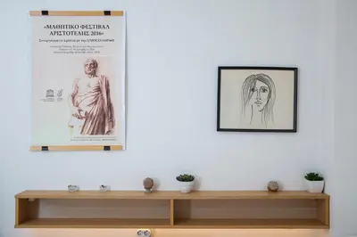 a wall with two posters and a shelf with plants at Comfy Apartment In Exarchia Vibrant Neighborhood in Athens