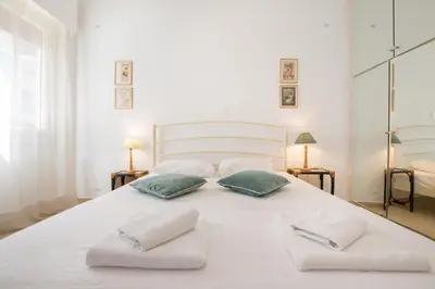 a large white bed with two pillows on it at Cute Retro Apartment In Exarchia Neighborhood in Athens
