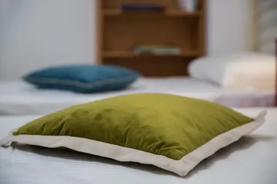 a green pillow sitting on top of a bed at Cute Retro Apartment In Exarchia Neighborhood in Athens