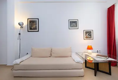 a living room with a couch and a glass table at Cute Retro Apartment In Exarchia Neighborhood in Athens