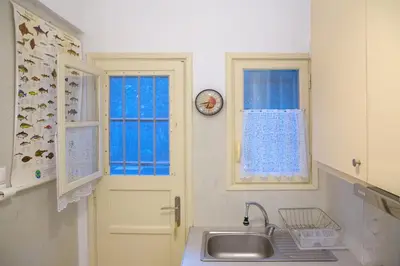 a kitchen with a sink and a clock on the wall at Cute Retro Apartment In Exarchia Neighborhood in Athens
