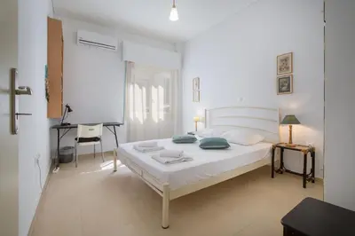 a white bedroom with a bed and a desk at Cute Retro Apartment In Exarchia Neighborhood in Athens