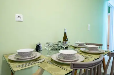 a dining room table with plates and a bottle of wine at Monastiraki Aélia Apartment by ΜΡS in Athens