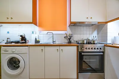 a kitchen with a sink and a washing machine at Monastiraki Aélia Apartment by ΜΡS in Athens
