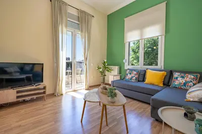 a living room with a blue couch and a tv at Monastiraki Aélia Apartment by ΜΡS in Athens