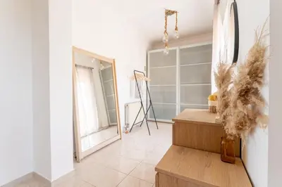 a white room with a table and a mirror at Rustic Garden Cabin in Vari