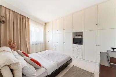 a bedroom with white cabinets and a bed at Rustic Garden Cabin in Vari