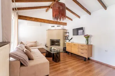a living room with a couch and a table at Rustic Garden Cabin in Vari