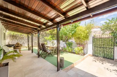 an outdoor patio with a wooden pergola at Rustic Garden Cabin in Vari