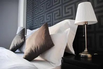 a bed with white pillows and a lamp on a table at Athens SmArt 3-Room Private Apartment in Athens