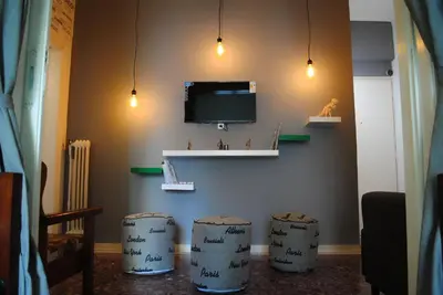 a living room with two stools and a tv on the wall at Athens SmArt 3-Room Private Apartment in Athens