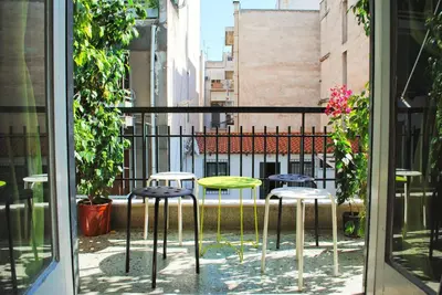 a balcony with three stools and a table and chairs at Athens SmArt 3-Room Private Apartment in Athens