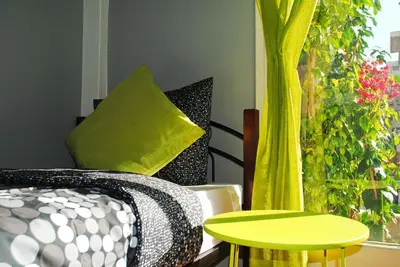 a room with a bed and a table and some plants at Athens SmArt 3-Room Private Apartment in Athens