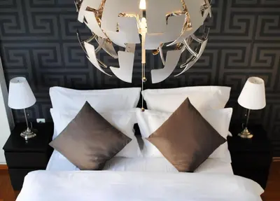 a bedroom with a white bed with pillows and a chandelier at Athens SmArt 3-Room Private Apartment in Athens