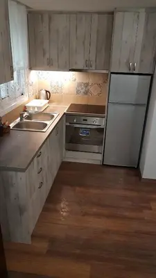 a kitchen with wooden cabinets and a sink and a refrigerator at Konstantinos Apartments in Athens