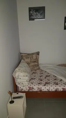 a bedroom with a bed with a comforter and a table at Konstantinos Apartments in Athens