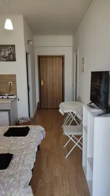 a room with two beds and a table and a television at Konstantinos Apartments in Athens