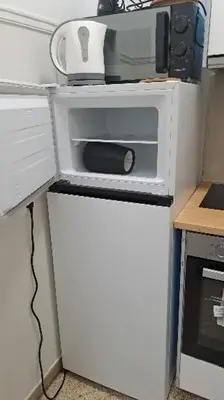 a small white refrigerator with a microwave on top of it at Skipper's Urban Endeavor One bed lux central quiet smart cozy apart Athens in Athens