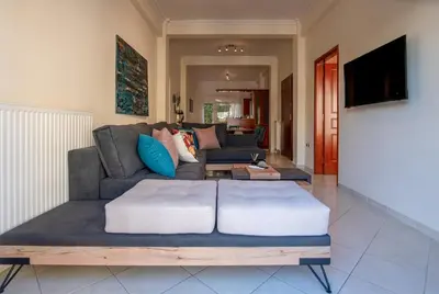 a living room with a couch and a tv at Near Metro 3 Bedrooms Fiber 100mbps in Athens