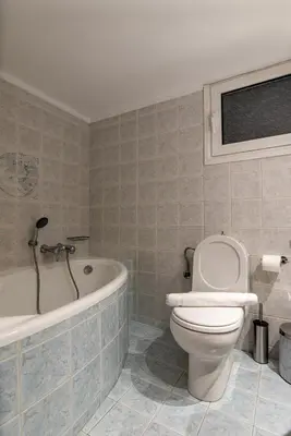 a bathroom with a toilet and a bath tub at Near Metro 3 Bedrooms Fiber 100mbps in Athens