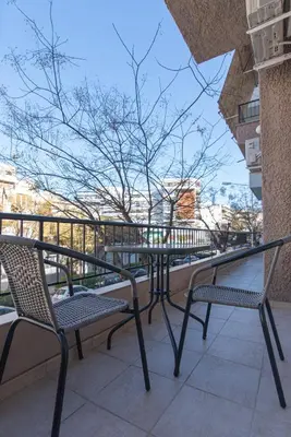 a patio with two chairs and a table on a balcony at Near Metro 3 Bedrooms Fiber 100mbps in Athens