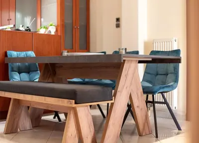 a wooden table with a bench and blue chairs at Near Metro 3 Bedrooms Fiber 100mbps in Athens