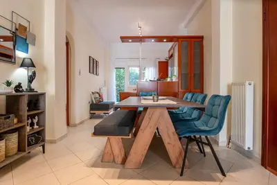 a dining room with a wooden table and blue chairs at Near Metro 3 Bedrooms Fiber 100mbps in Athens