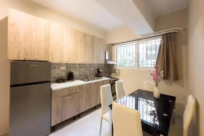 a kitchen with a stainless steel refrigerator and a table at Koukaki Comfort - Modern 2BR near Acropolis by ΜΡS in Athens