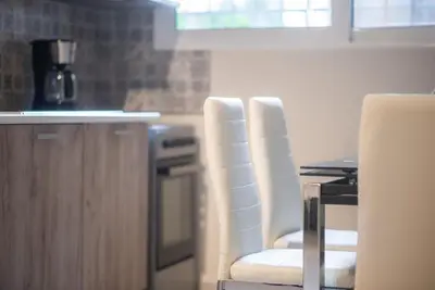 a kitchen with two white chairs and a table at Koukaki Comfort - Modern 2BR near Acropolis by ΜΡS in Athens