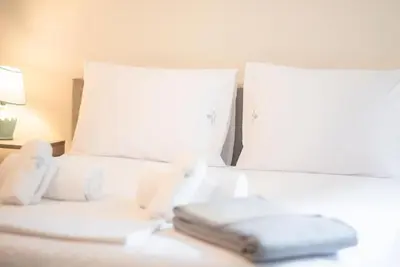 a bed with two white pillows and a book on it at Koukaki Comfort - Modern 2BR near Acropolis by ΜΡS in Athens