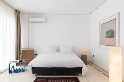 a white bedroom with a bed and a window at Serenity Penthouse with terrace in Exarcheia in Athens