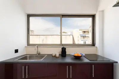 a kitchen with a sink and a large window at Serenity Penthouse with terrace in Exarcheia in Athens