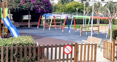 a playground with colorful swings in a park at GreenGarden Comfort in Athens