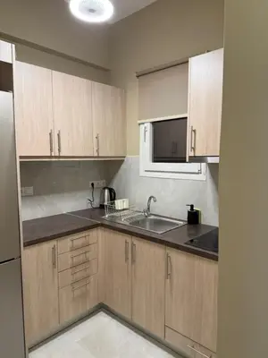 a kitchen with wooden cabinets and a sink and a microwave at Gaia Athens Apartment in Athens