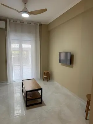 a living room with a table and a tv on the wall at Gaia Athens Apartment in Athens