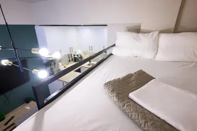 a bedroom with a bed with white sheets and pillows at Amorgou maisonette in Athens