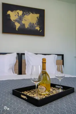 a tray with a bottle and two wine glasses on a bed at Ariadne - Elegant & Chic House in Egaleo-Athens in Athens