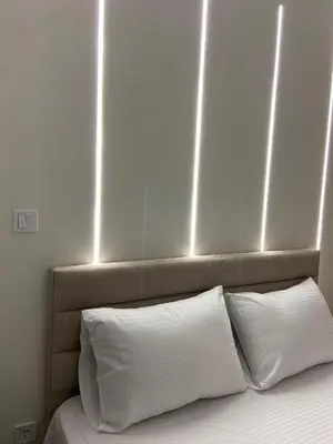 a bed with white pillows and lights above it at Dear Athens Suite in Athens