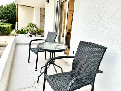 a patio with three chairs and a table on a porch at Urban Calm Glyfada Getaway 2BD in Athens