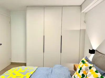 a bedroom with white cabinets and a bed at Urban Calm Glyfada Getaway 2BD in Athens